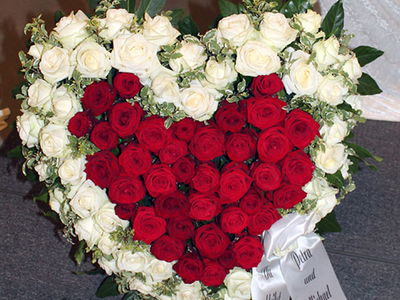 Herzgesteck mit weißen und roten Rosen