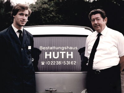 Altes Foto von Thomas Huth und Hans Theo Huth vor einem Bestattungswagen